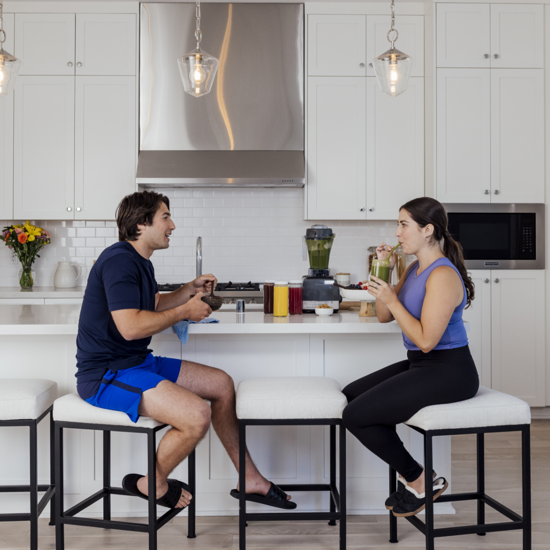 Man and woman enjoying a smoothie in luxury kitchen