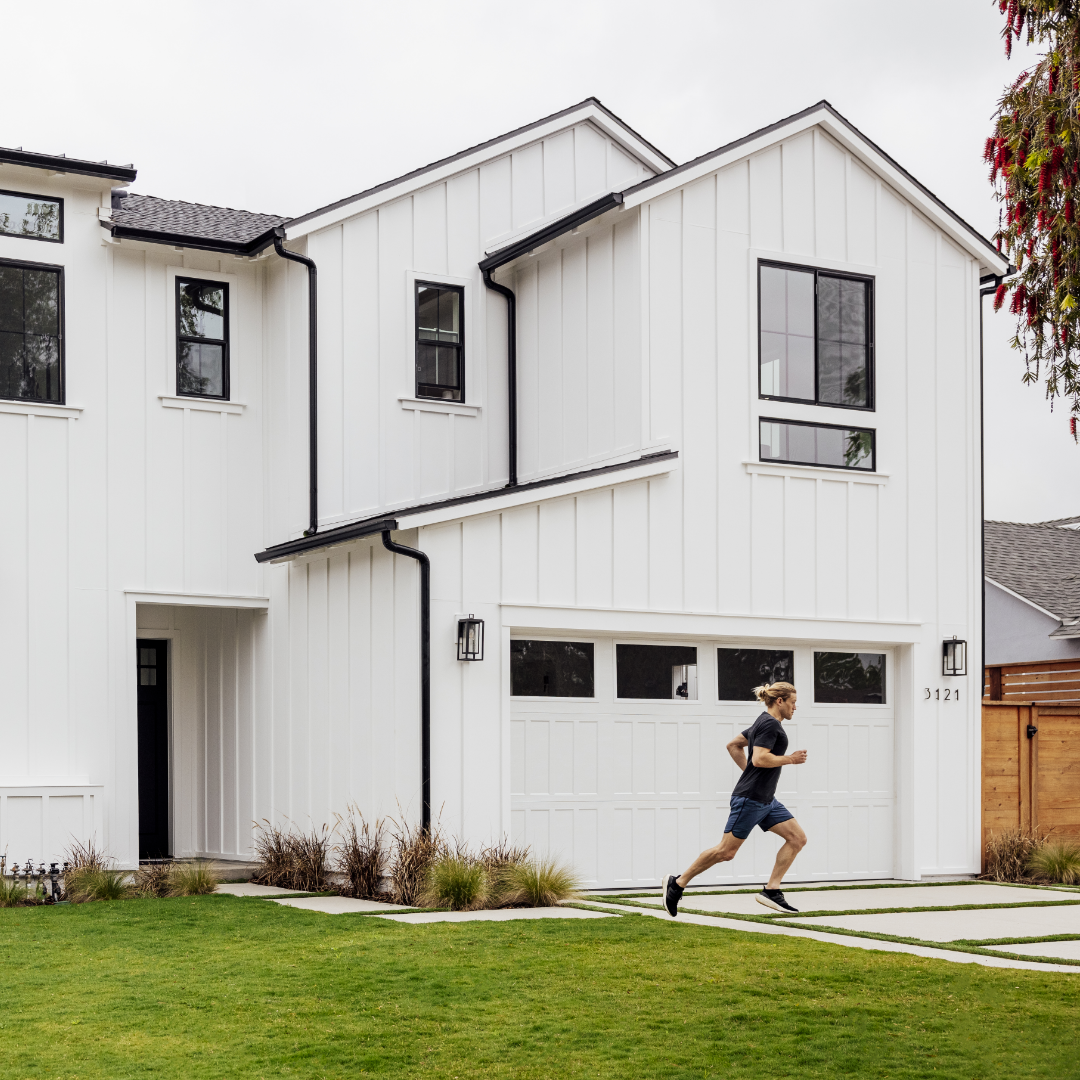 White Farmhouse-style exterior with male runner