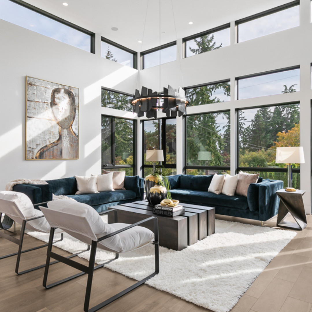 Luxury contemporary living room with floor to ceiling windows and high ceilings.