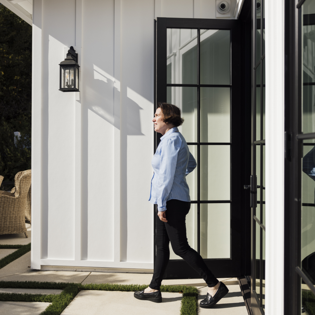 TJH Happy Homeowner, Maureen, exits her black french door onto backyard patio