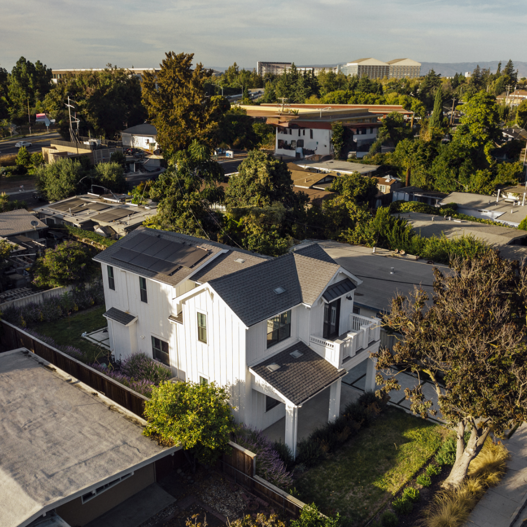 Aerial photo of white farmhouse-style home by Thomas James Homes