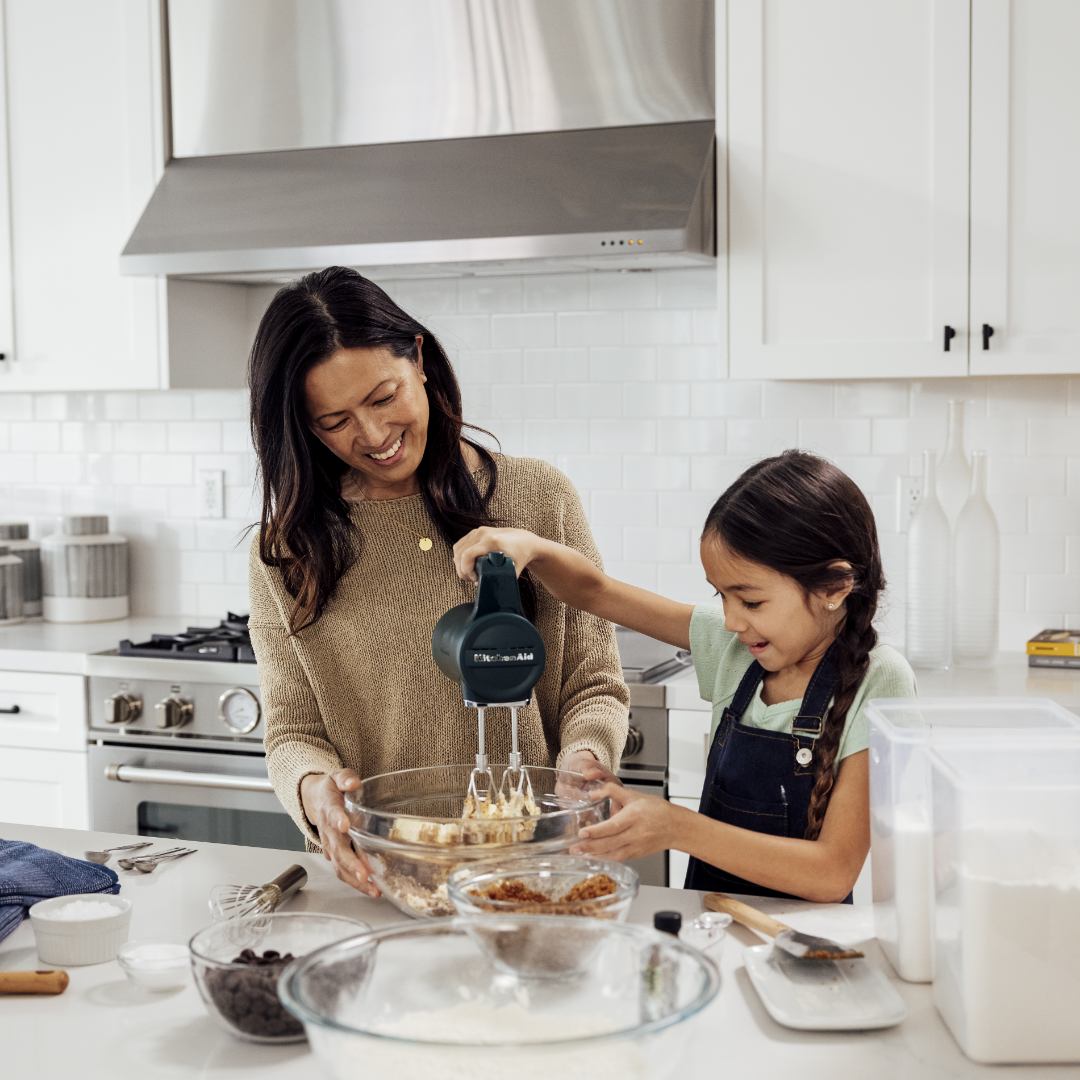 Image of mother and young daughter making cookies in all-white TJH kitchen