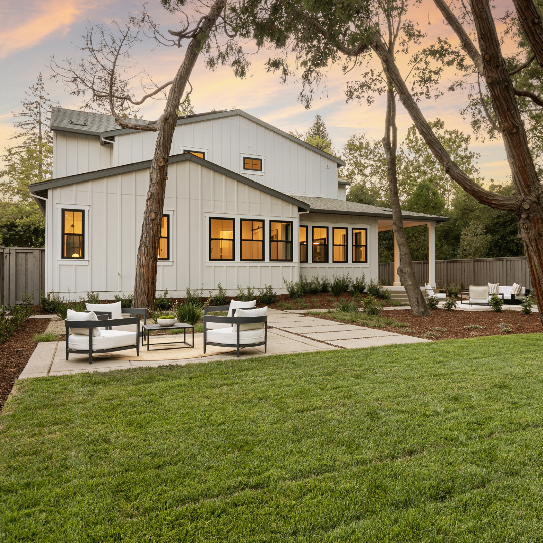 Image of backyard of farmhouse-style TJH home with grass and patio spaces