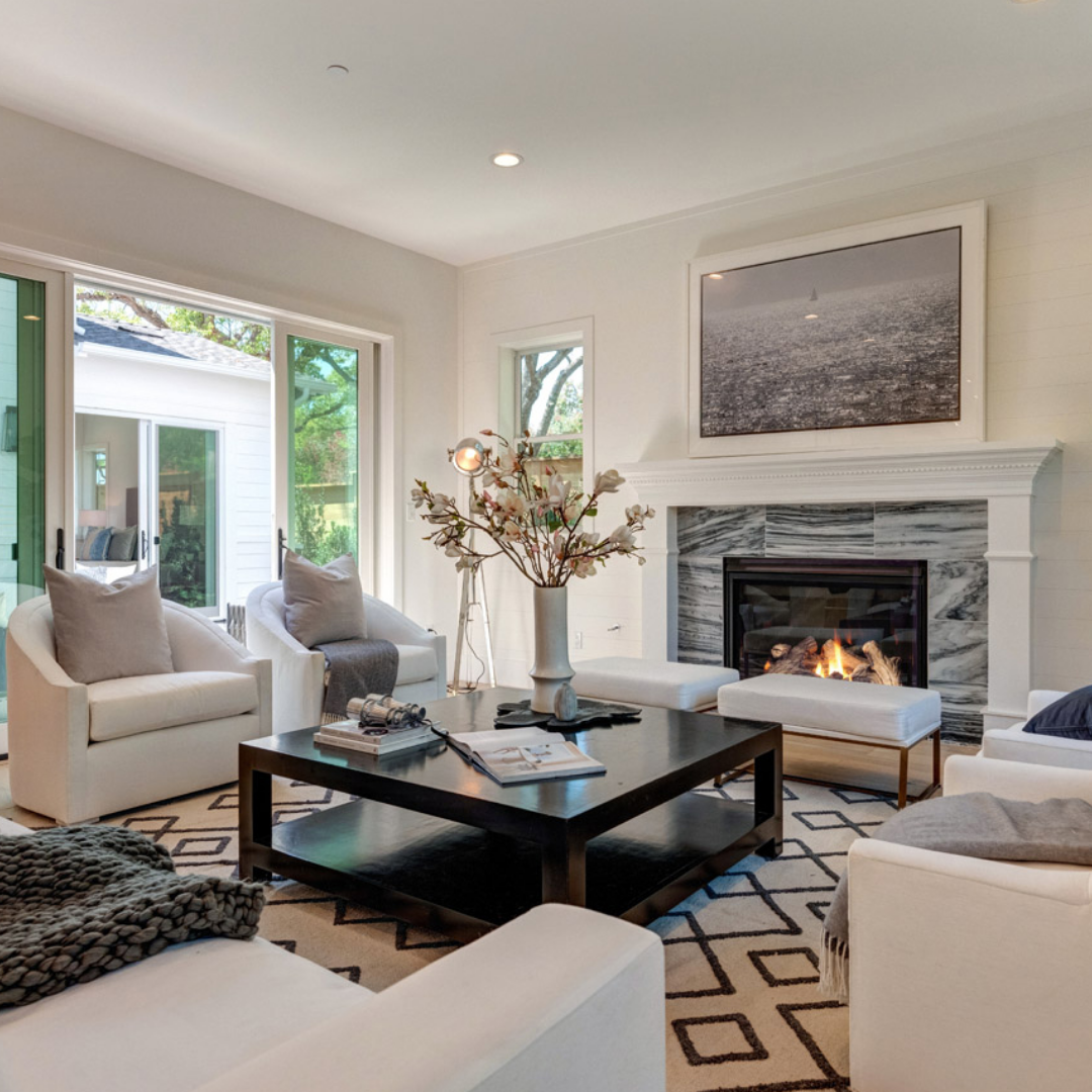 Luxury living room by Thomas James Homes with sliding glass door and beige decor and marble tile surround fireplace