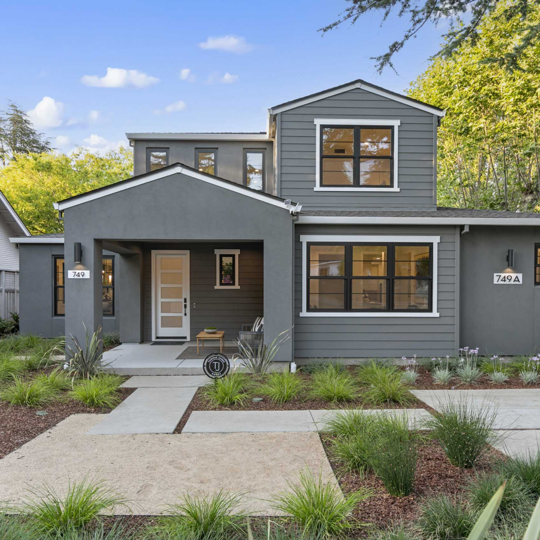 Exterior of transitional-style TJH home with gray siding and black window casings