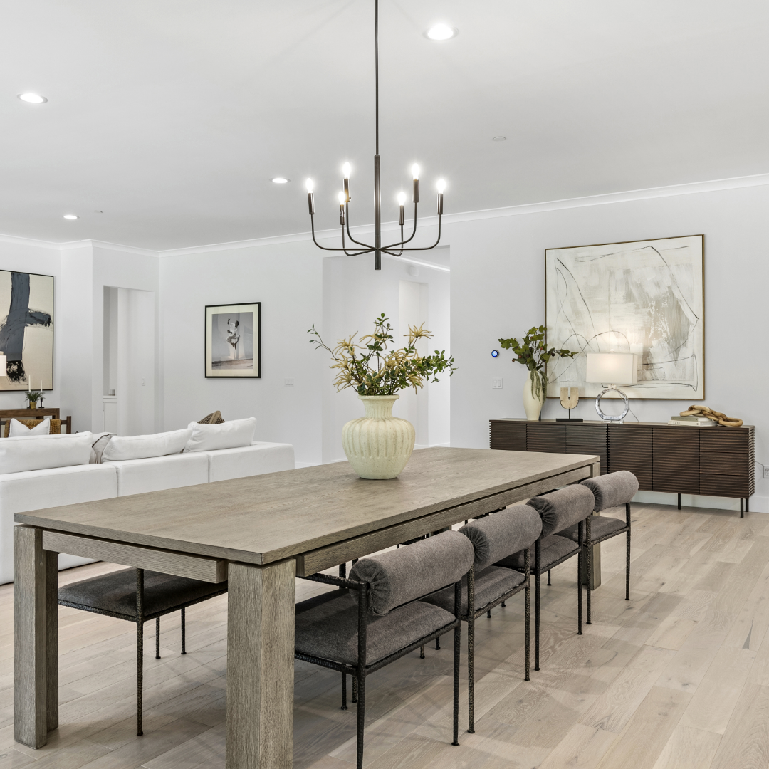 Image of dining space + great room in luxury TJH home with white walls, white oak flooring and organic modern furniture