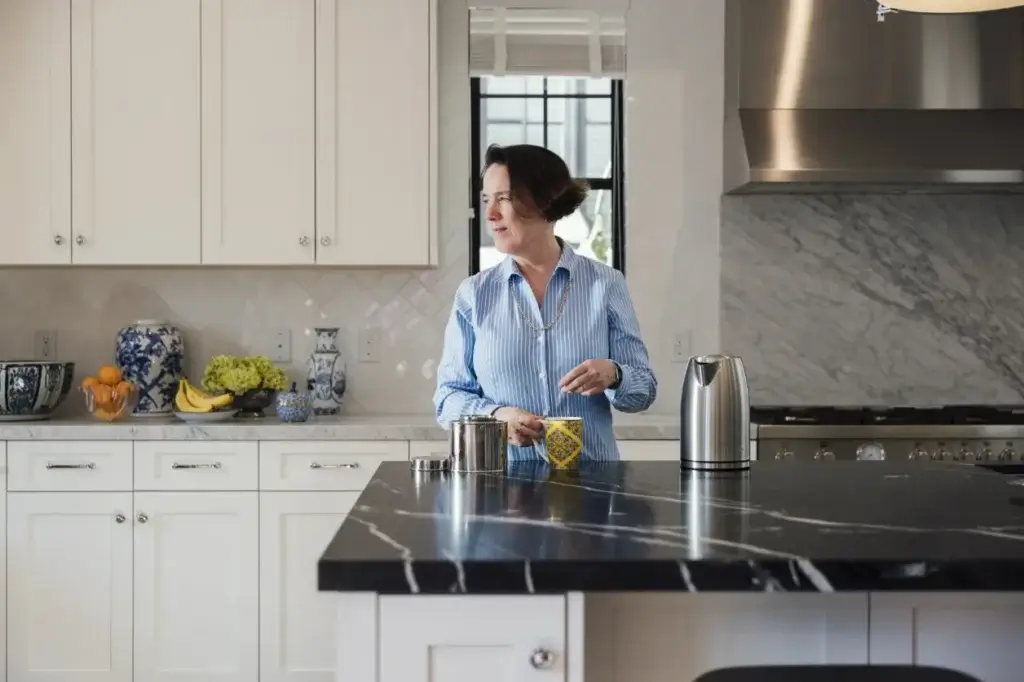 Woman in a kitchen preparing a cup of tea