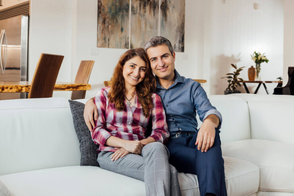 Homeowners sitting together in their newly built TJH home, reflecting a personalized design and seamless building experience
