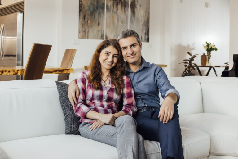 Homeowners sitting together in their newly built TJH home, reflecting a personalized design and seamless building experience