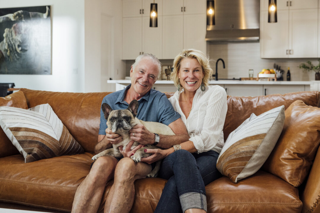 Arizona homeowners sitting on a couch with their dog in a bright, modern living room.