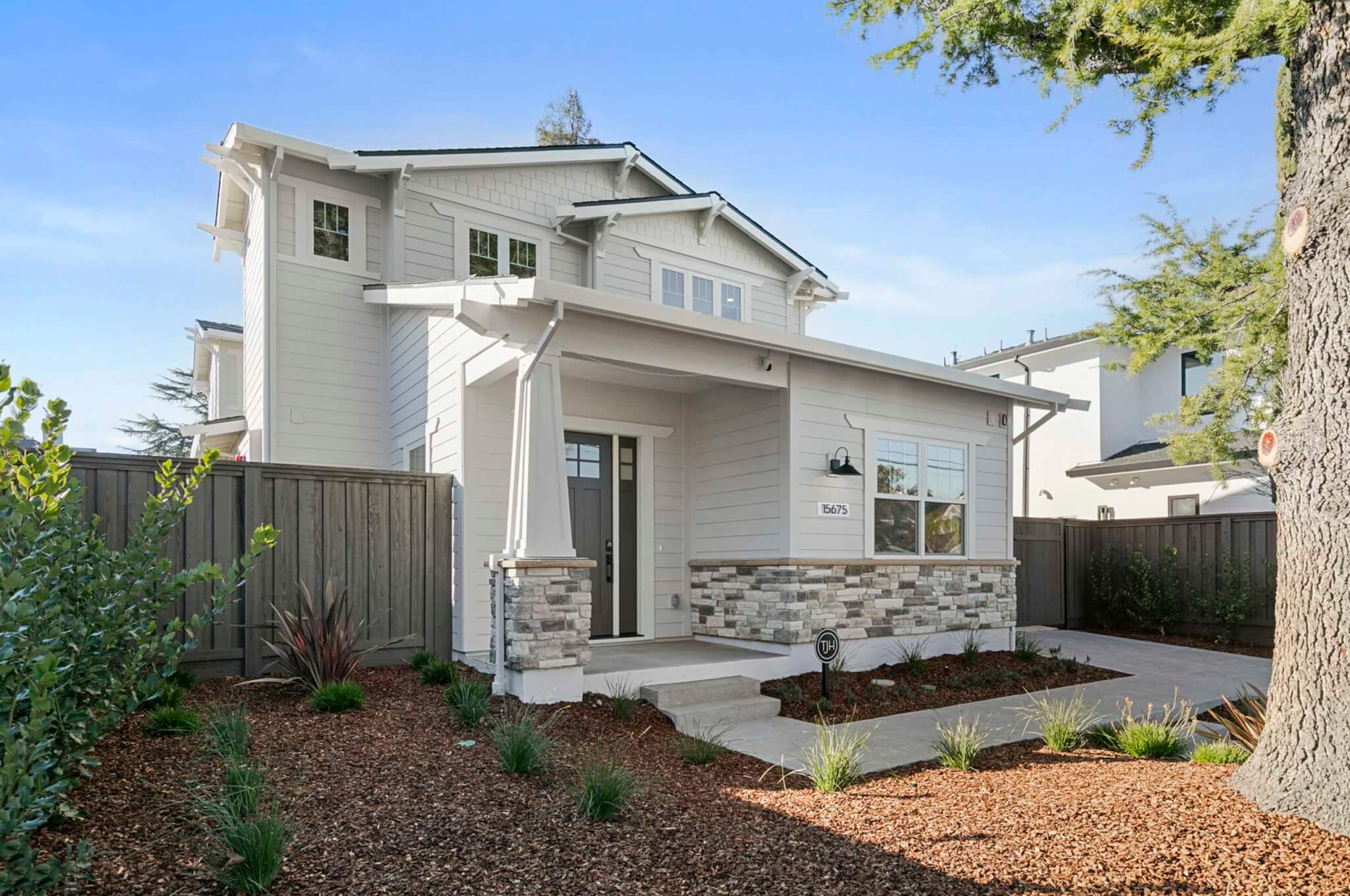 Newly constructed two-story residence featuring a welcoming covered porch, clean architectural lines, and thoughtfully designed landscaping.