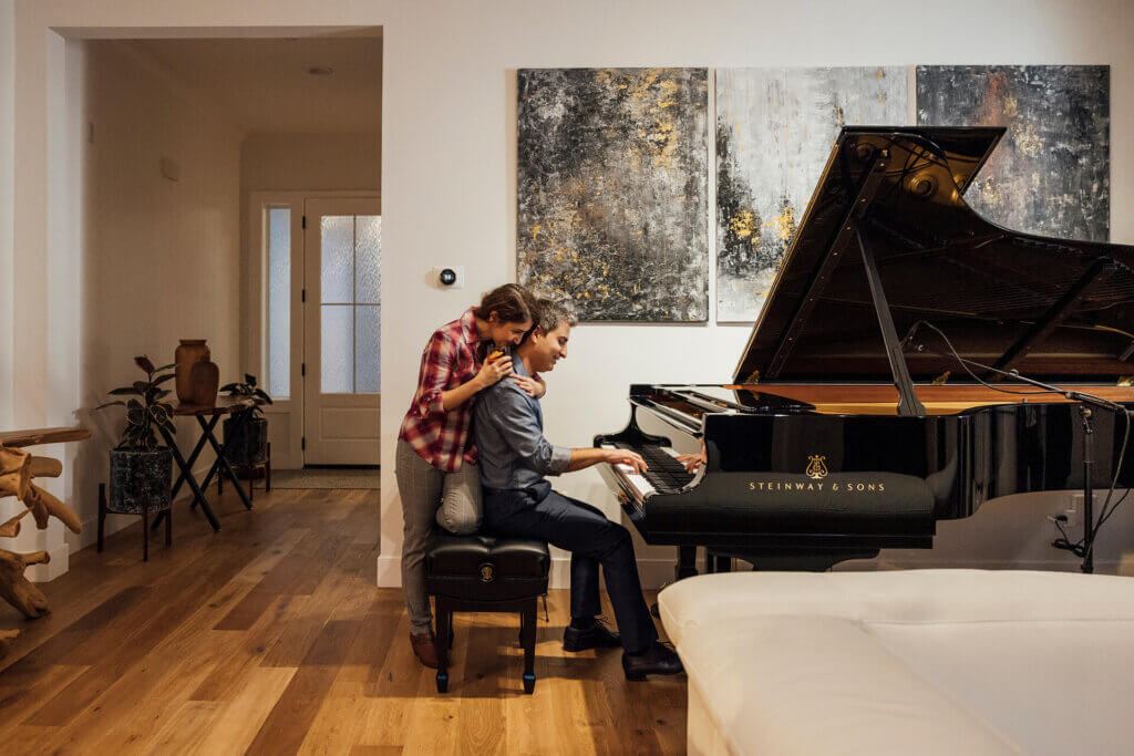 TJH Northern California homeowner plays piano while a loved one leans in — a moment of joy in their new home