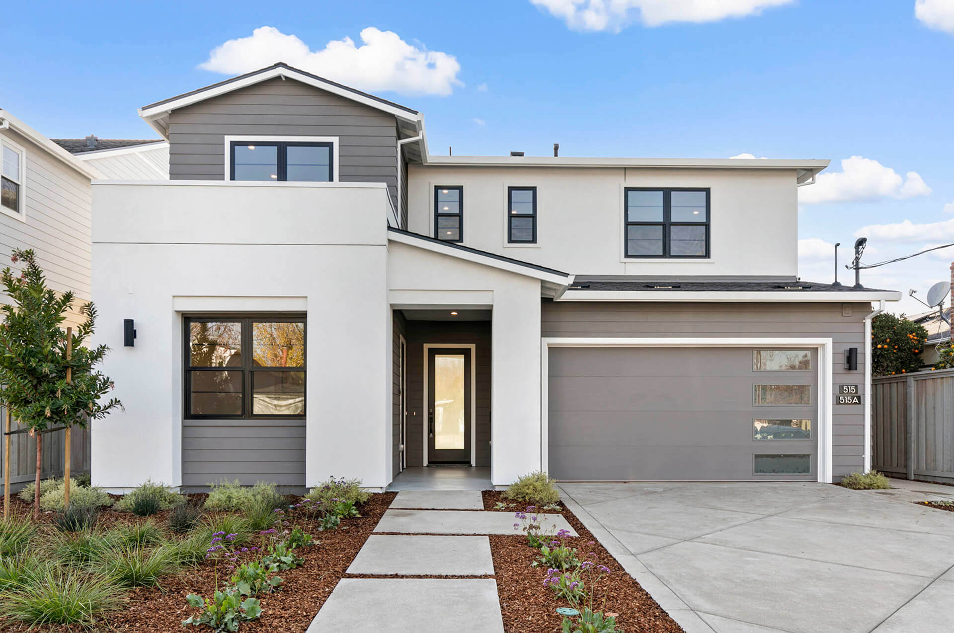 TJH Maple two-story with gray and white exterior, large windows, and double garage