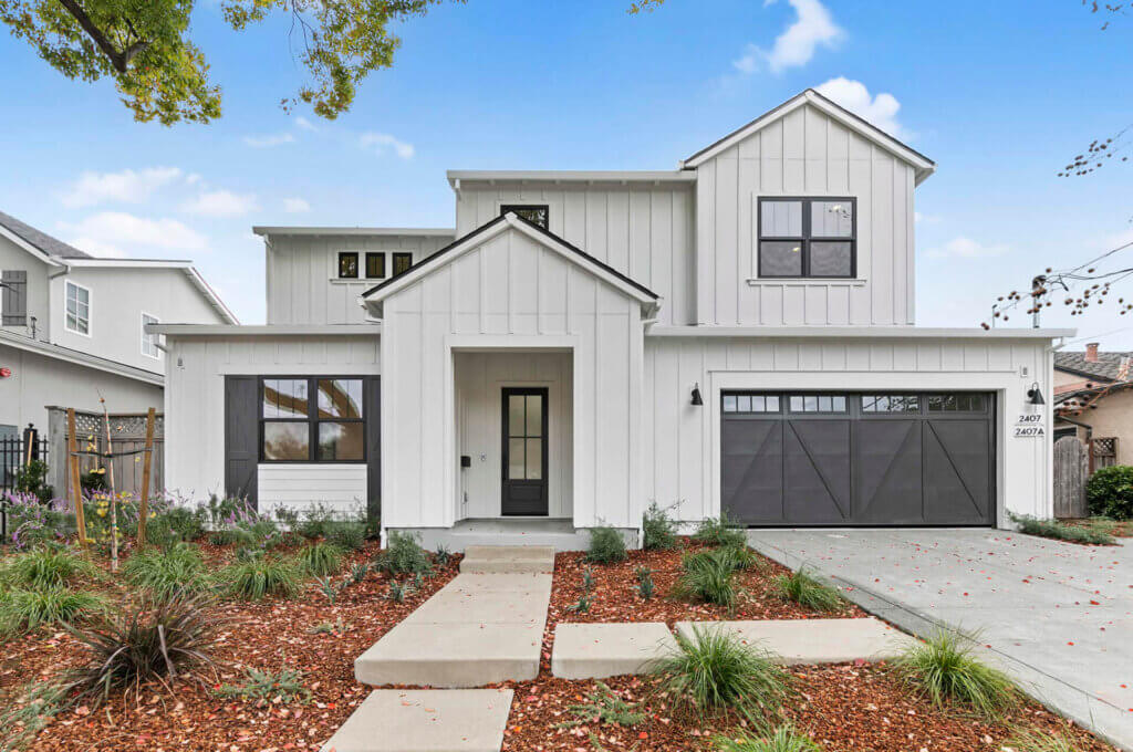 TJH Verbena — white two-story with black trim, large windows, and double dark garage doors