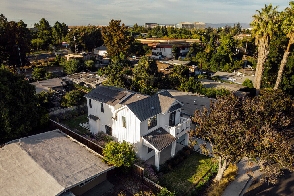 Aerial view of a TJH Northern California home with solar panels and manicured landscaping in a well-established neighborhood