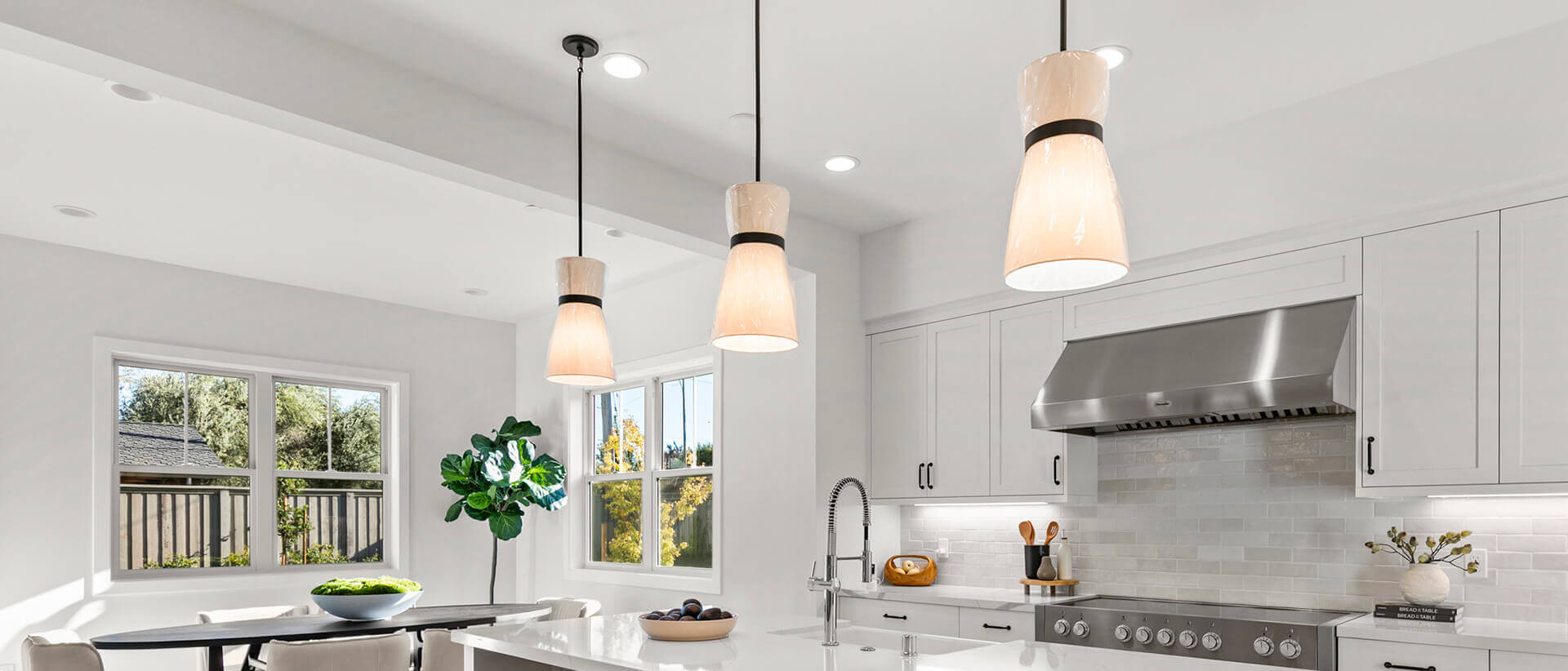 TJH Verbena kitchen with white cabinetry, large island with barstools, and stainless appliances