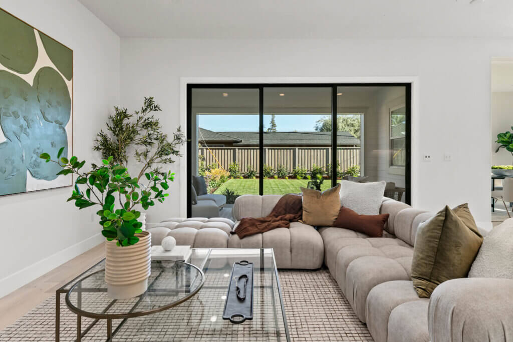 TJH Verbena living room with beige sectional, green and brown cushions, and glass coffee table