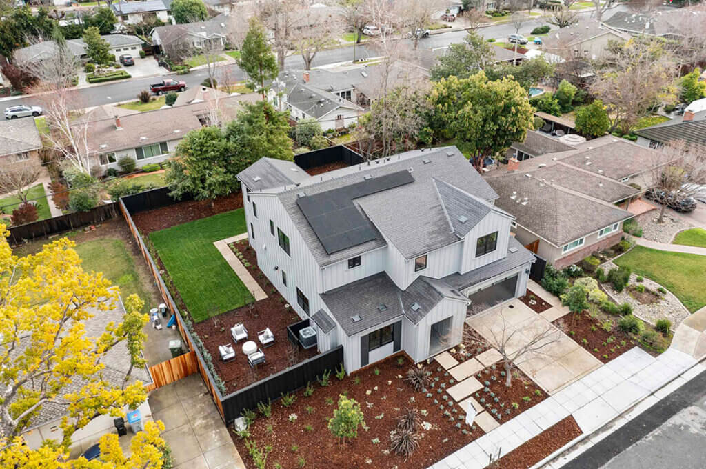 Aerial view of TJH Verbena with solar panels, fenced backyard, and outdoor seating area