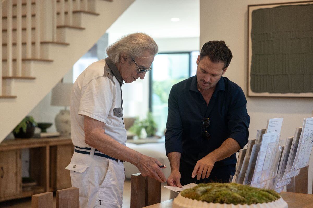 A homeowner reviews floorplan and home design information with a Thomas James Homes representative during a Pacific Palisades home planning consultation.