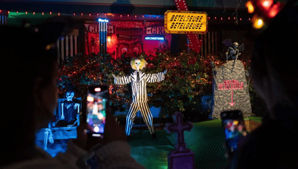 person photographing a halloween display of the movie beetlejuice